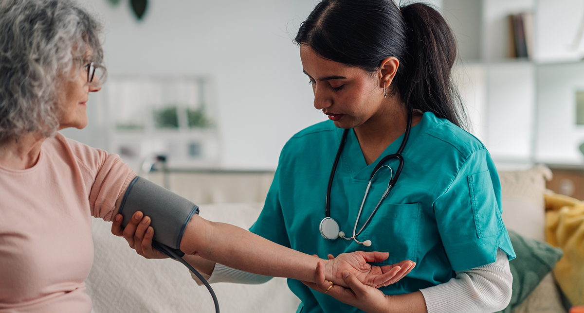 Nurse monitoring an elderly woman's blood pressure