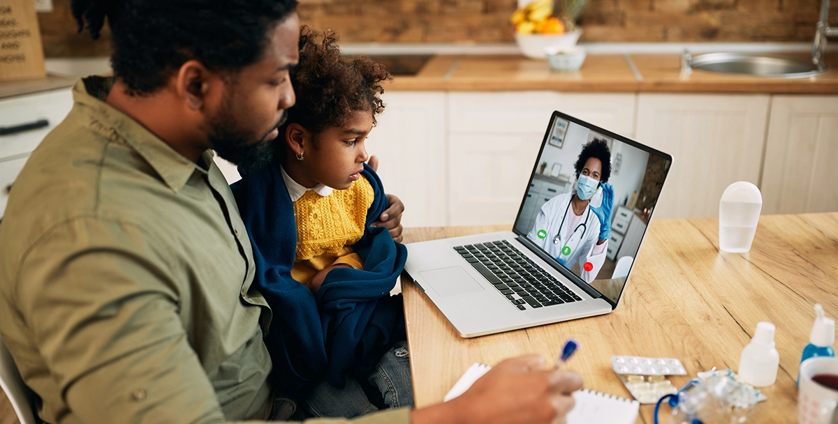 Father and daughter having a video call with their doctor